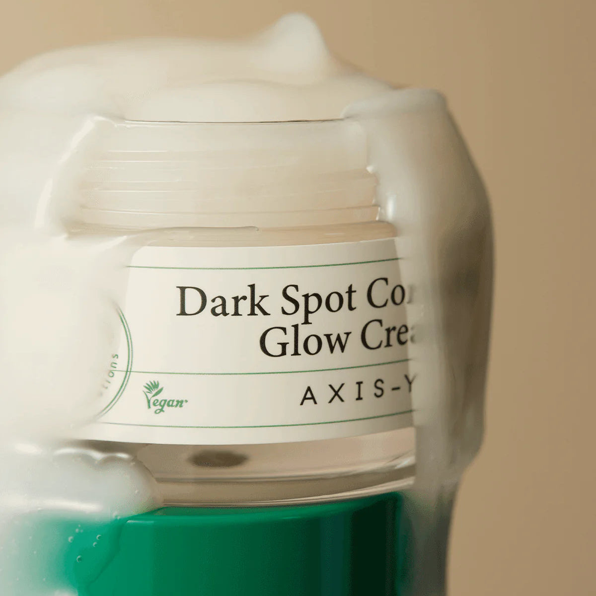 Jar of Axis-Y Dark Spot Correcting Glow Cream on a beige background