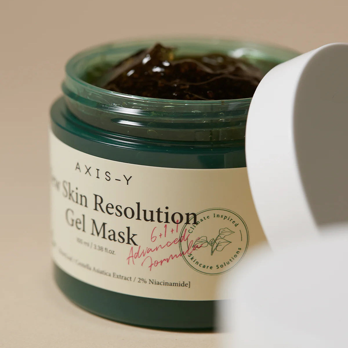AXIS-Y Skin Resolution Gel Mask jar with a white applicator on a beige background